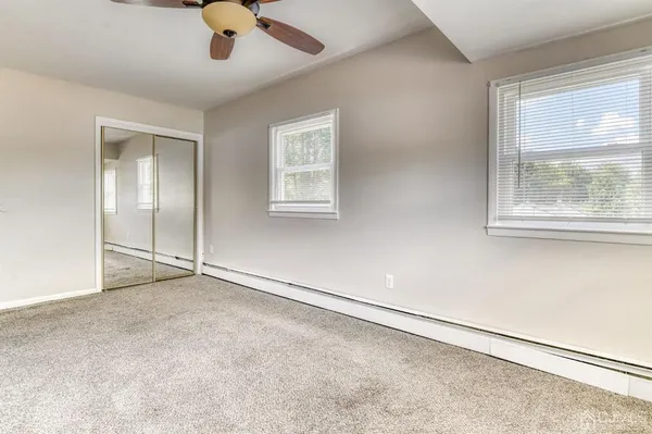 an empty room with a window and a ceiling fan