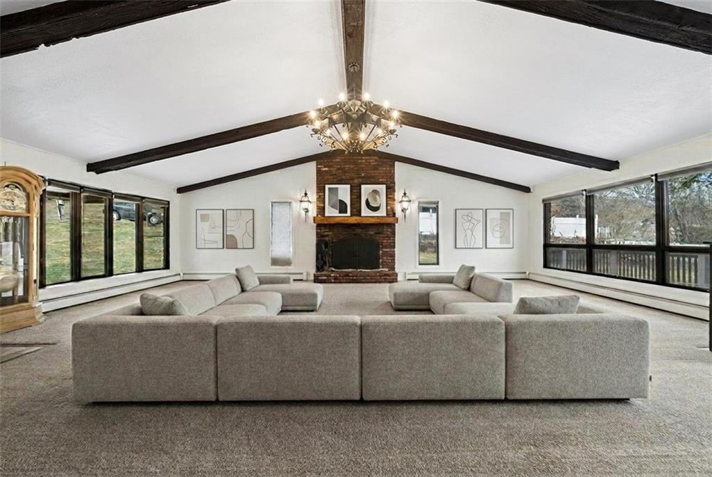 255 Poplar Street Monroeville, PA 15146 - Photo 7 of 44 The oversized living room is a standout; vaulted ceilings, abundant natural light, and a wood burning fireplace create a warm, open gathering space overlooking the front yard and opening out onto the deck – perfect for entertaining. Virtually Staged