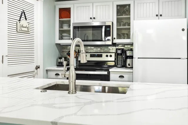 a kitchen with stainless steel appliances kitchen island wooden cabinets and a refrigerator