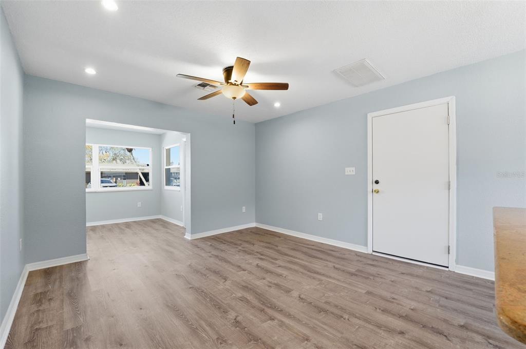 5153 Turquoise Lane, Unit 102 New Port Richey, FL 34652 - Photo 14 of 29 an empty room with wooden floor chandelier fan and windows