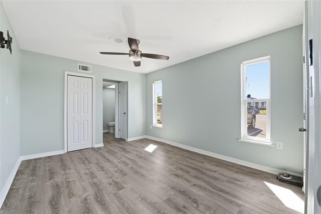 5153 Turquoise Lane, Unit 102 New Port Richey, FL 34652 - Photo 23 of 29 an empty room with wooden floor ceiling fan and windows