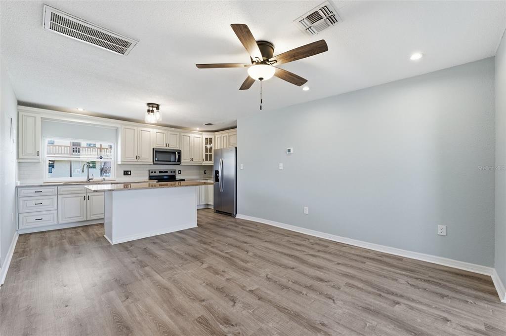 5153 Turquoise Lane, Unit 102 New Port Richey, FL 34652 - Photo 6 of 29 a kitchen with a refrigerator and white cabinets