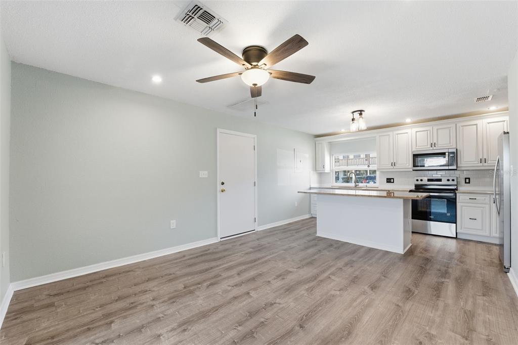 5153 Turquoise Lane, Unit 102 New Port Richey, FL 34652 - Photo 7 of 29 a kitchen with granite countertop a stove cabinets and wooden floor