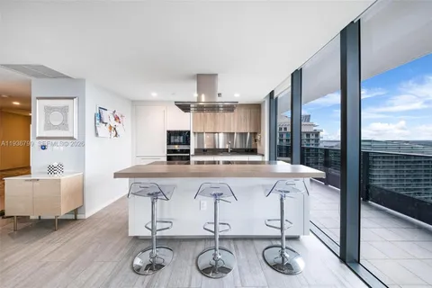 a large white kitchen with a large window