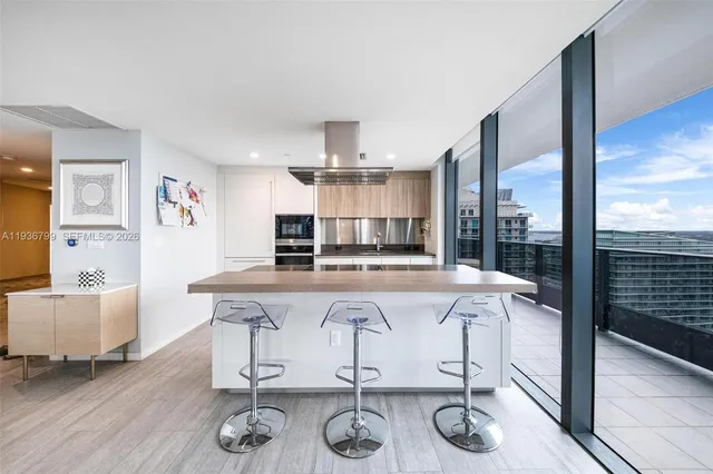 a large white kitchen with a large window