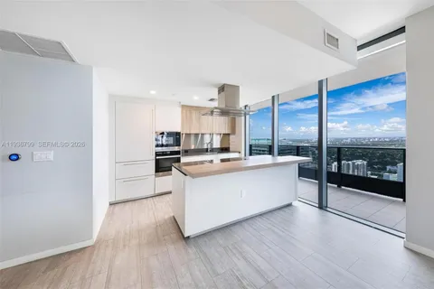 a large kitchen with stainless steel appliances double vanity and a large window