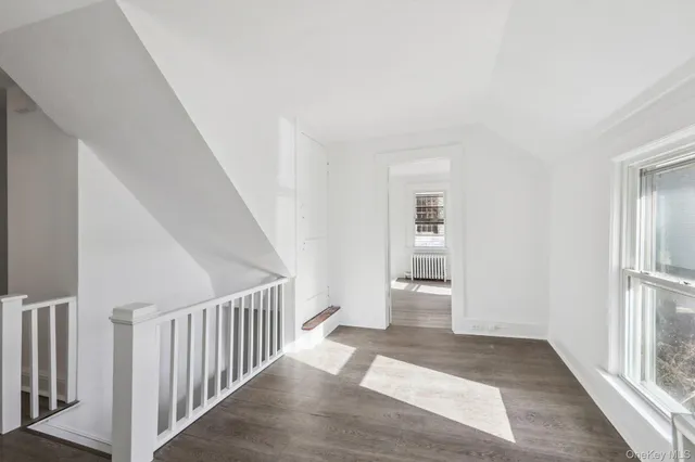 a view of a hallway with wooden floor and entryway