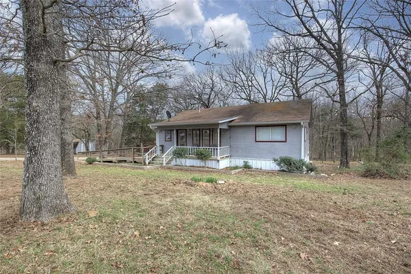 a front view of a house with a garden and trees