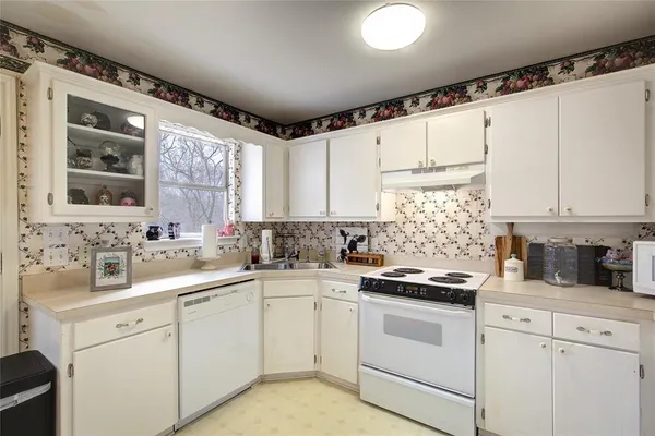 a kitchen with white cabinets sink and appliances