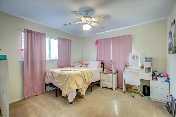 a spacious bedroom with a bed and a ceiling fan