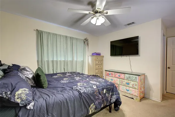 a bedroom with a bed a television and a large window