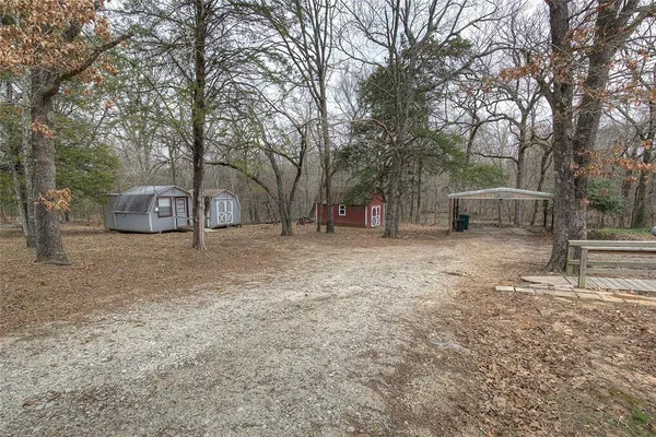 a view of a house with a yard and a large tree