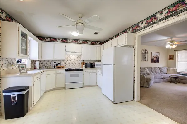 a kitchen with a refrigerator a sink and cabinets