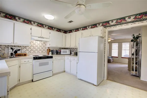 a kitchen with refrigerator a sink and cabinets