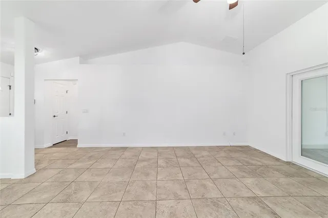 a view of a big room with windows and chandelier fan