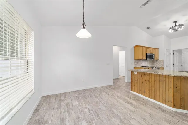 a kitchen with granite countertop a stove a sink and a microwave