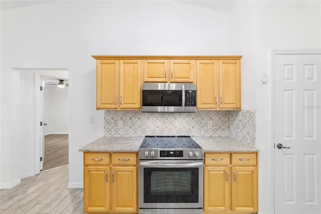 a view of a hallway with wooden floor and a bathroom