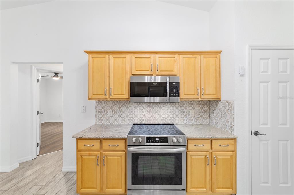 13688 Southwest 113th Lane Dunnellon, FL 34432 - Photo 32 of 70 a kitchen with granite countertop a stove a sink and a microwave