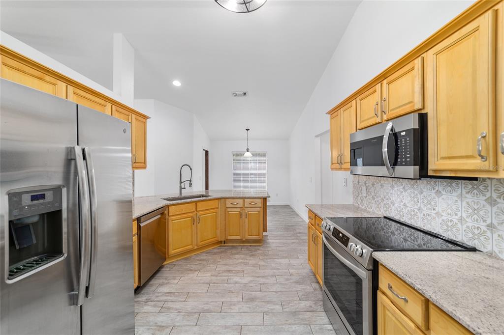 13688 Southwest 113th Lane Dunnellon, FL 34432 - Photo 34 of 70 a kitchen with stainless steel appliances granite countertop a stove a sink and a microwave