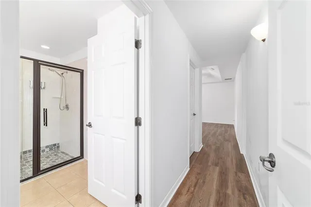 an empty room with wooden floor and a ceiling fan