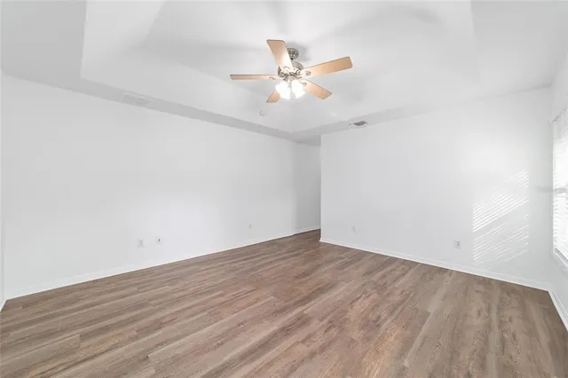 a view of empty room with wooden floor