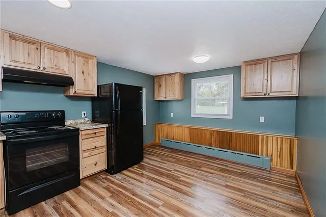 a kitchen with stainless steel appliances granite countertop a refrigerator and a stove top oven