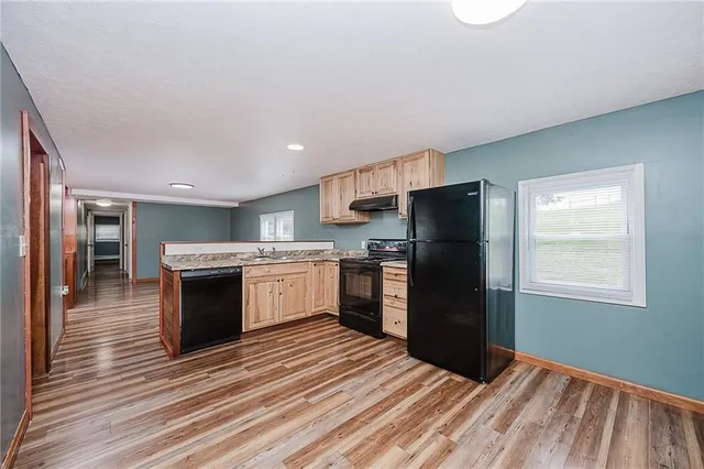 a kitchen with granite countertop a refrigerator stove and oven