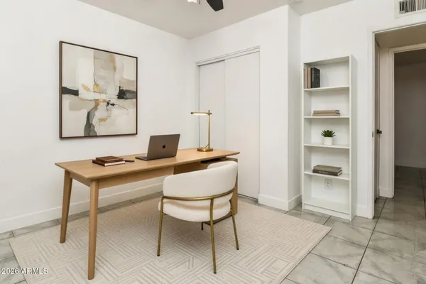 a spacious bedroom with a bed and a chandelier