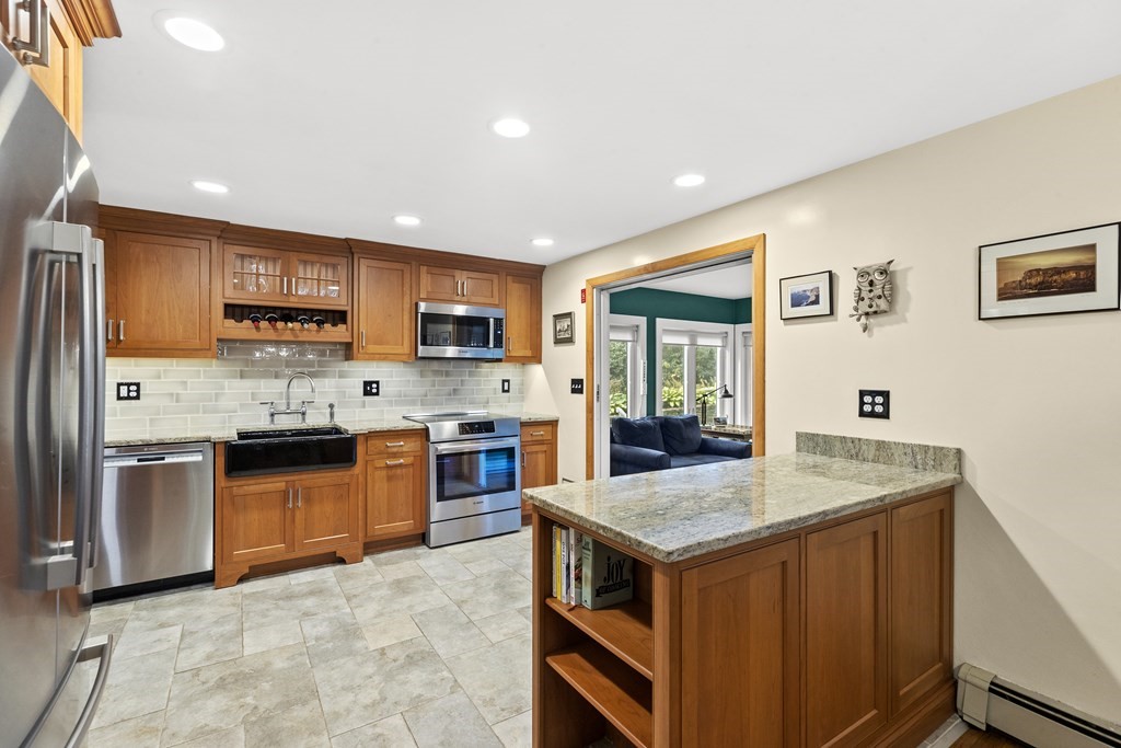 30 Eaton Road Framingham, MA 01701 - Photo 8 of 36 a kitchen with stainless steel appliances granite countertop a refrigerator a stove top oven a sink dishwasher and wooden cabinets