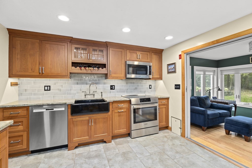 30 Eaton Road Framingham, MA 01701 - Photo 9 of 36 a kitchen with stainless steel appliances granite countertop a stove top oven a sink dishwasher and a refrigerator with wooden cabinets