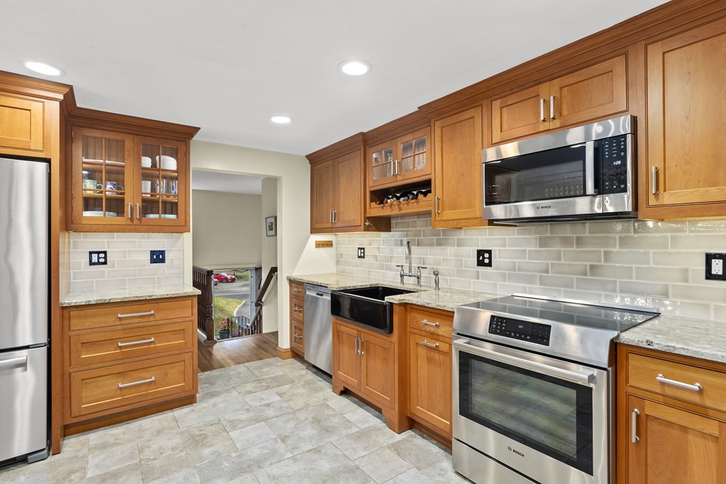 30 Eaton Road Framingham, MA 01701 - Photo 10 of 36 a kitchen with stainless steel appliances granite countertop a stove top oven a sink dishwasher and a microwave oven with large cabinets