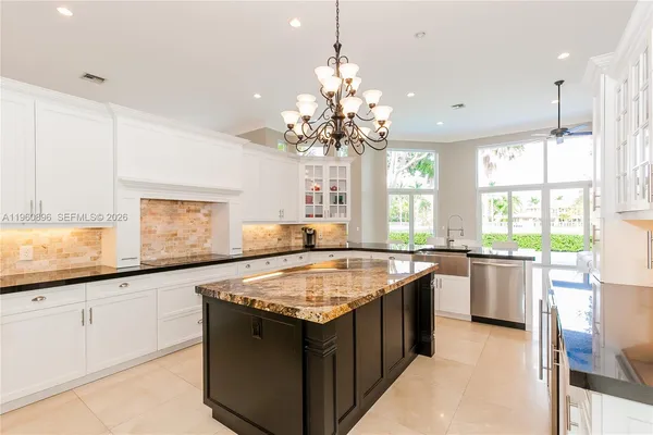 a kitchen with granite countertop white cabinets and white appliances