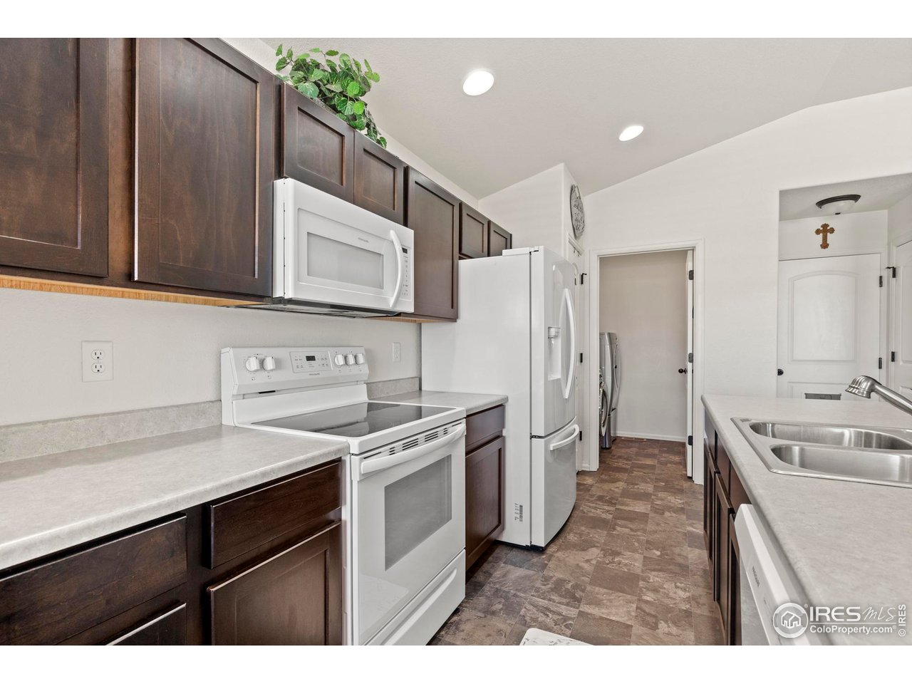 941 Barasingha Street Severance, CO 80550 - Photo 14 of 46 a kitchen with a sink stove and refrigerator