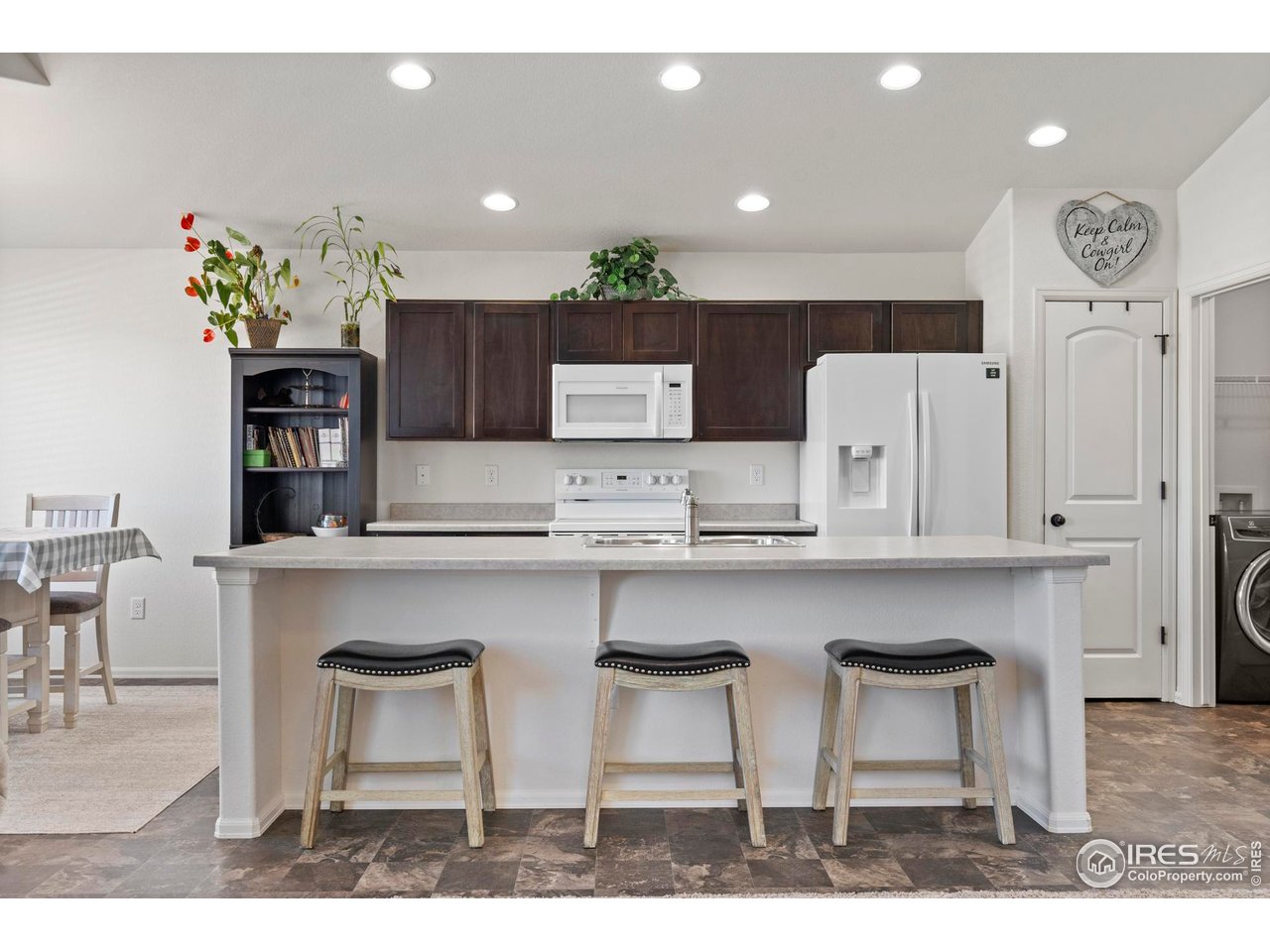 941 Barasingha Street Severance, CO 80550 - Photo 16 of 46 a kitchen with cabinets a counter space and a view of living room