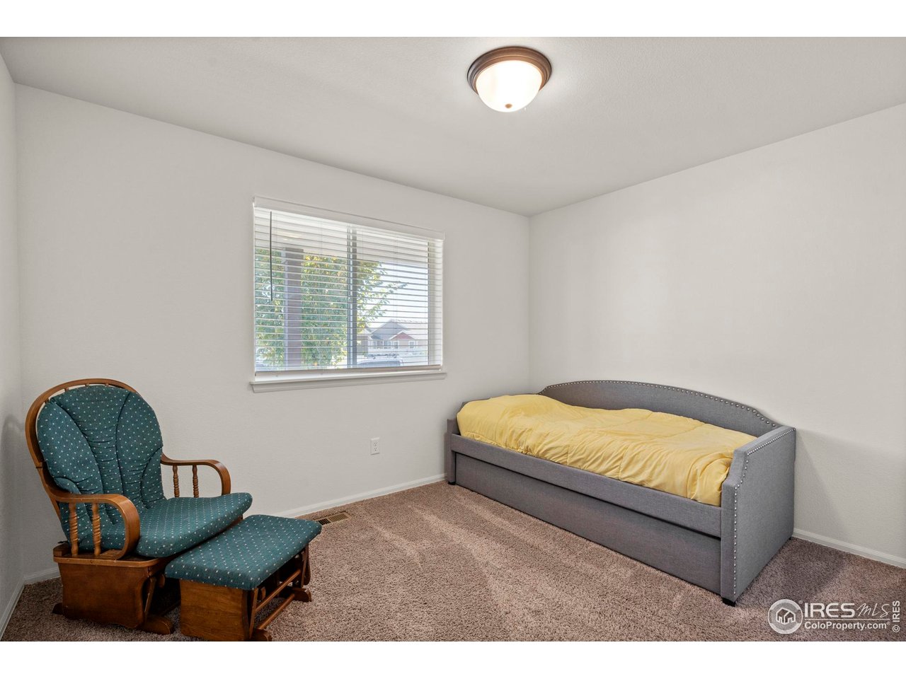 941 Barasingha Street Severance, CO 80550 - Photo 21 of 46 a bedroom with a bed and a chair