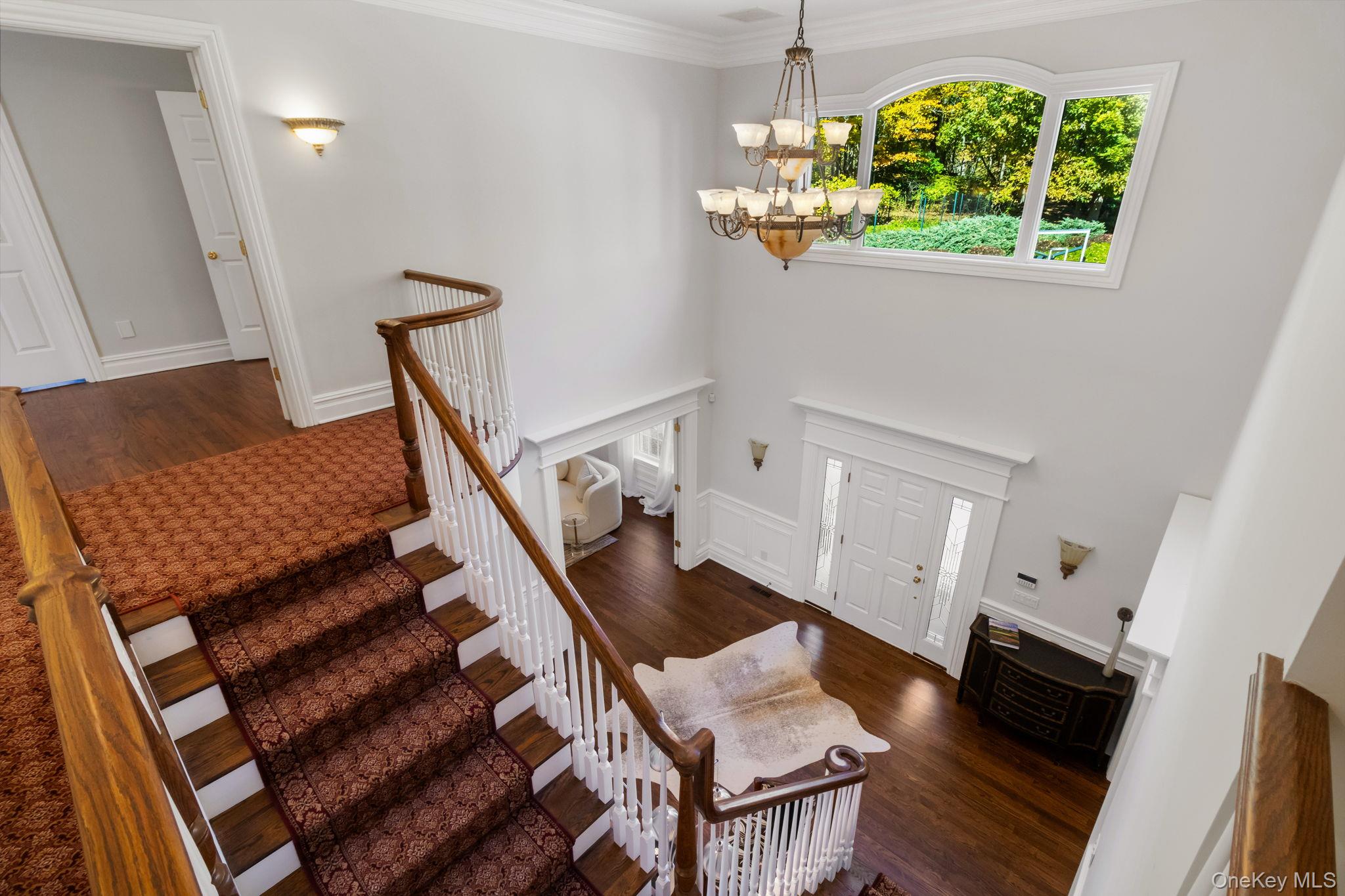 496 Long Ridge Road Bedford, NY 10576 - Photo 22 of 49 Foyer featuring stairway, dark wood finished floors, a chandelier, and crown molding