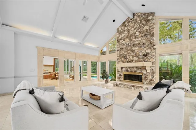 a living room with furniture and a dining table next to a window