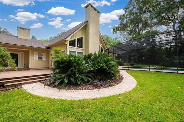 an aerial view of a house with swimming pool and garden