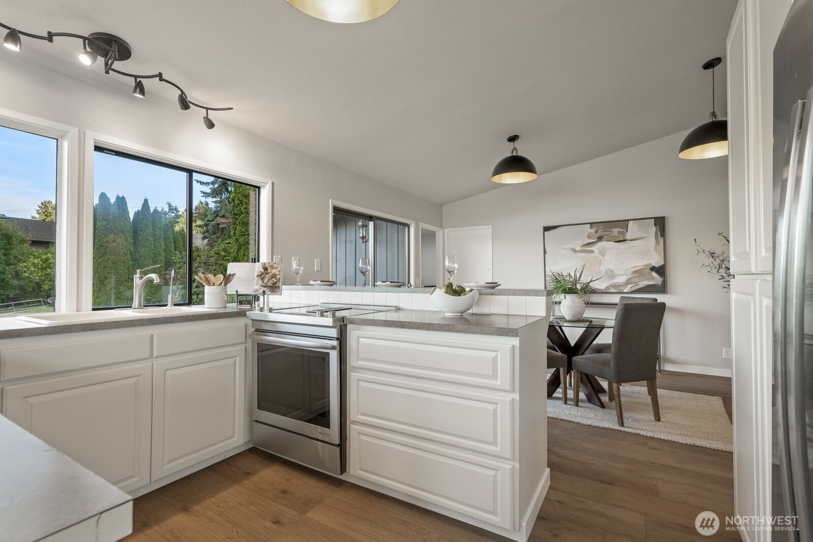 5110 Northwest Sammamish Road Issaquah, WA 98027 - Photo 15 of 40 a kitchen with a stove and white cabinets with wooden floor