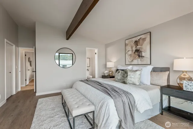 a bedroom with a large bed and a painting on the wall