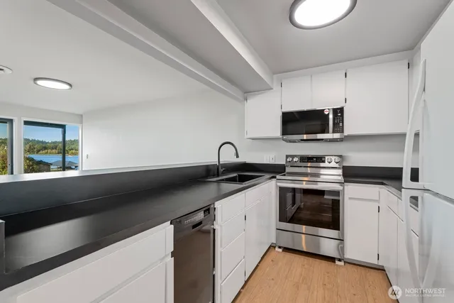 a view of a kitchen with a sink and stainless steel appliances