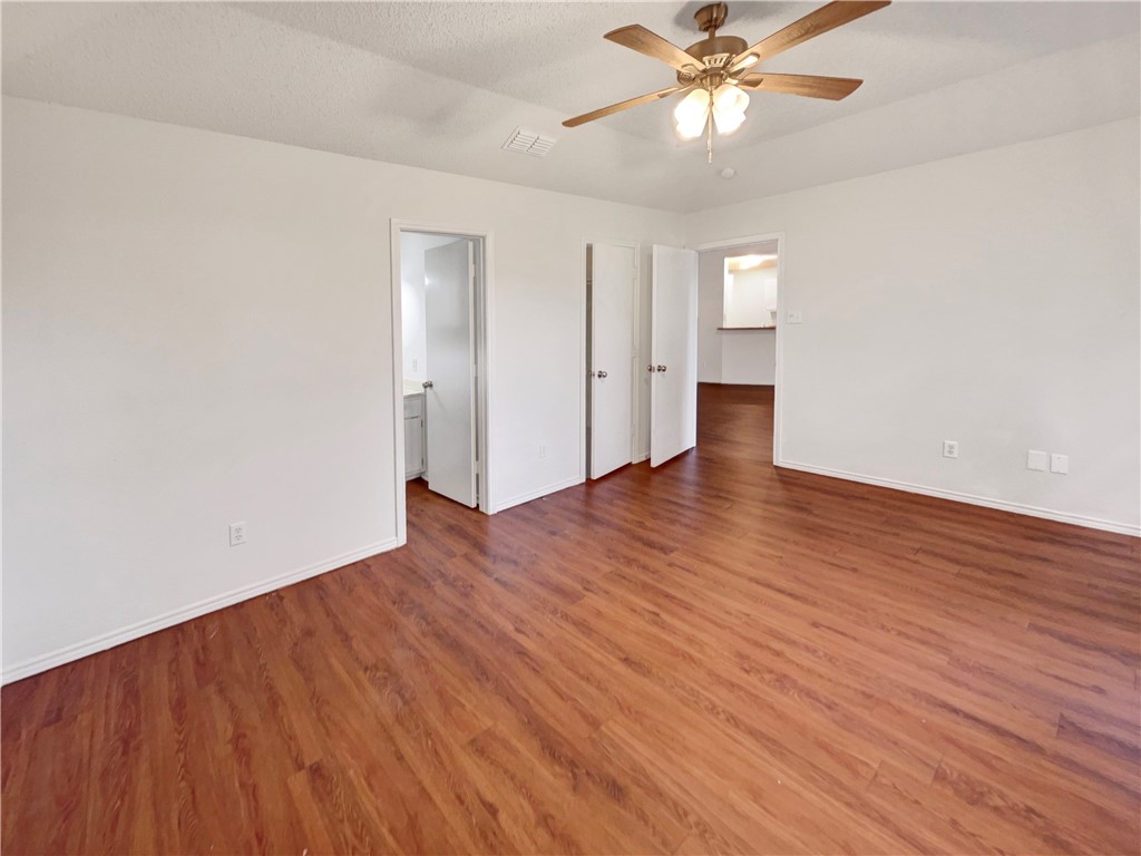 2090 Ridgewood Circle Ingleside, TX 78362 - Photo 4 of 16 an empty room with wooden floor chandelier fan and windows in a room
