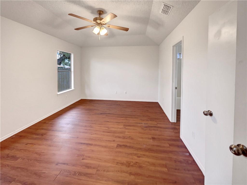 2090 Ridgewood Circle Ingleside, TX 78362 - Photo 10 of 16 an empty room with wooden floor chandelier fan and windows