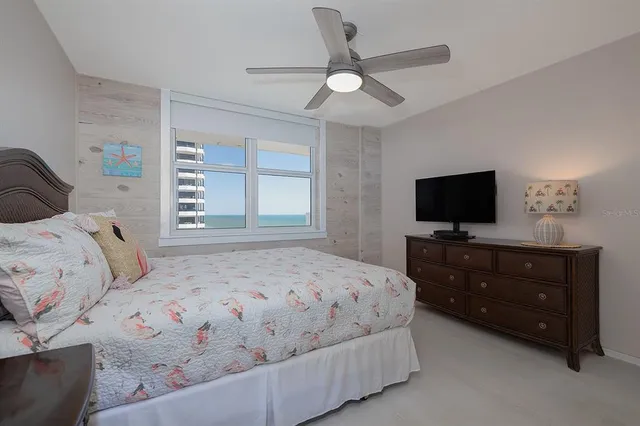 a bedroom with a bed and a ceiling fan