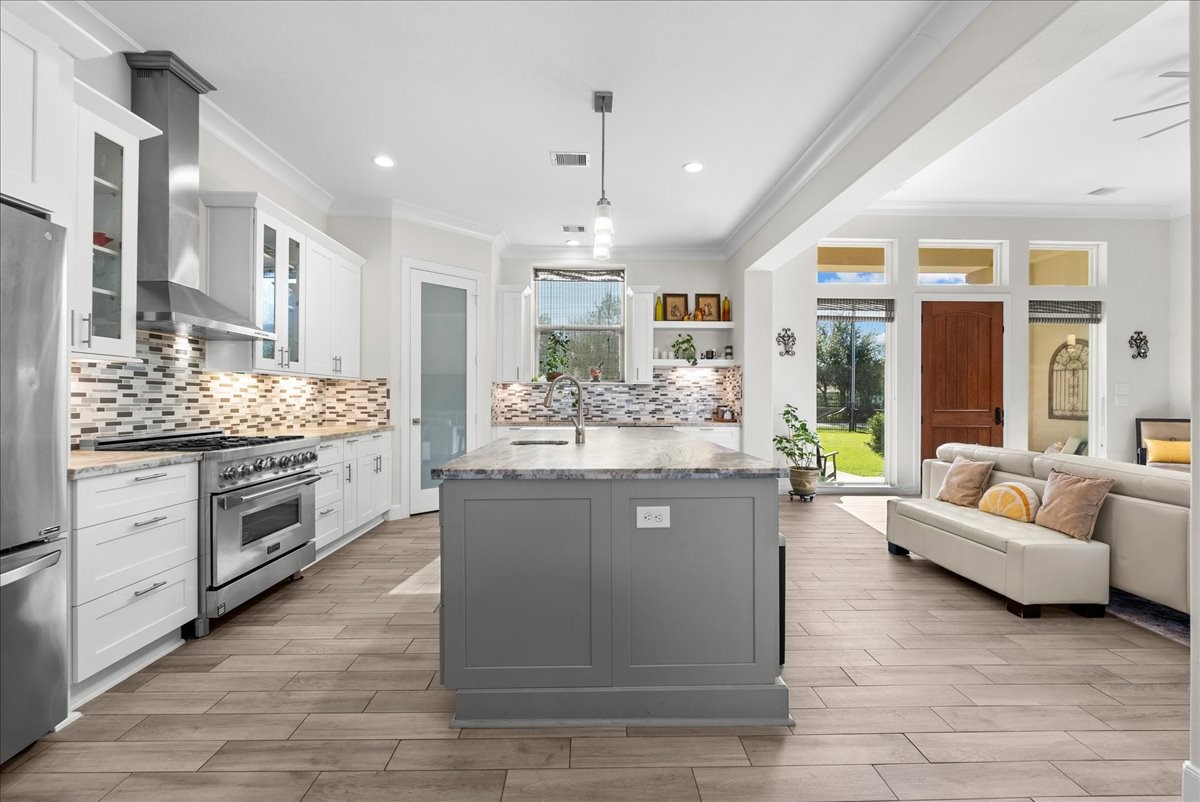 3706 Tower Road Santa Fe, TX 77517 - Photo 17 of 48 a large living room with stainless steel appliances kitchen island granite countertop furniture and a chandelier