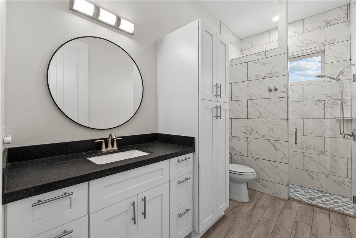 3706 Tower Road Santa Fe, TX 77517 - Photo 34 of 48 a bathroom with a granite countertop sink a toilet and a mirror
