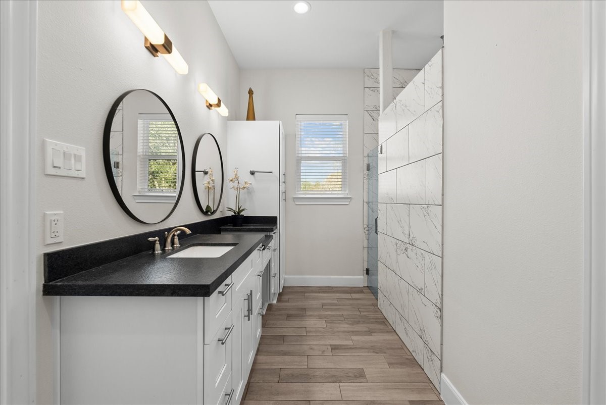3706 Tower Road Santa Fe, TX 77517 - Photo 38 of 48 a bathroom with a granite countertop sink a mirror and a shower