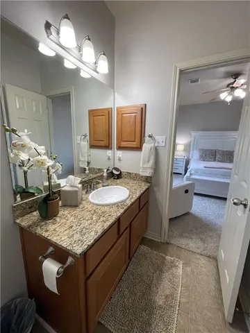 a bathroom with a granite countertop sink a light fixture and a mirror