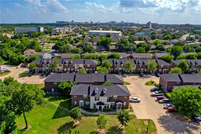 an aerial view of a houses with a swimming pool outdoor seating and yard