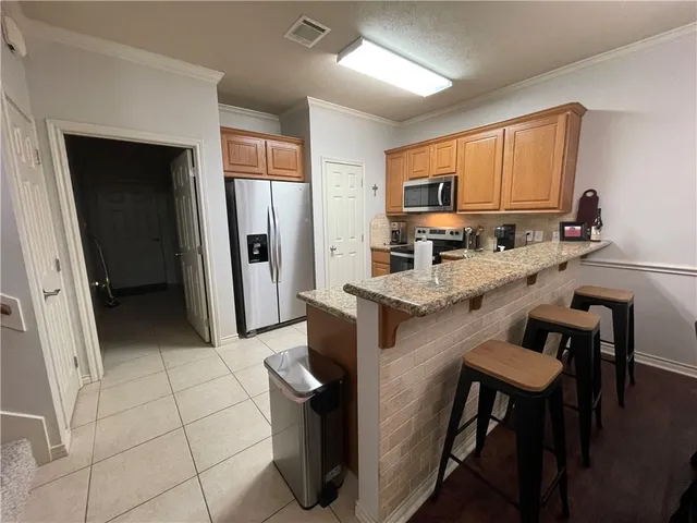 a kitchen with stainless steel appliances granite countertop a refrigerator and a stove top oven
